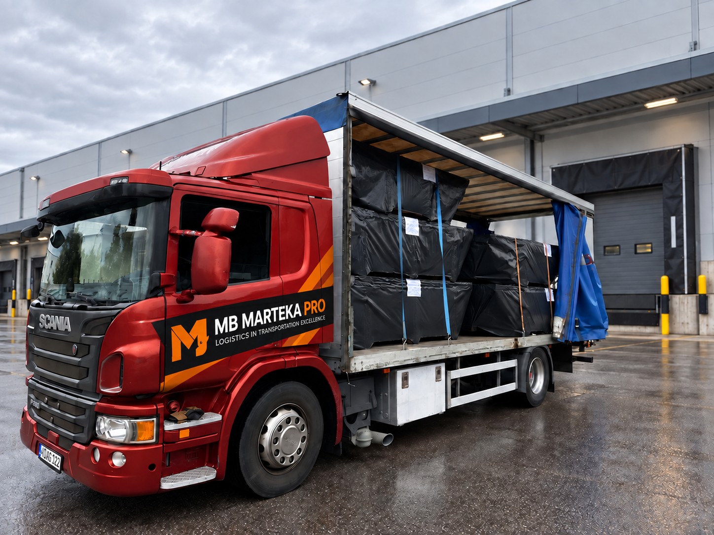 Raudona Scania prie sandėlio pakrovimo vartų